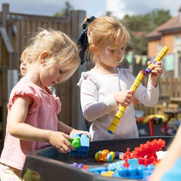 Early childhood learning at Monkey Puzzle Day Nurseries, children engaging with educational toys outdoors.